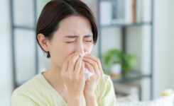 室内で鼻をかむ女性