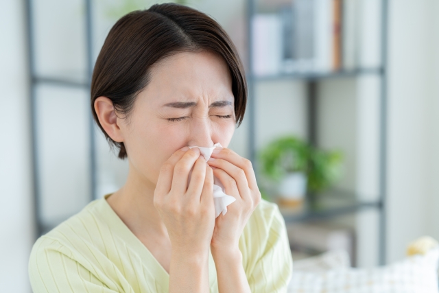 室内で鼻をかむ女性